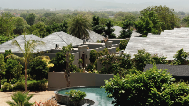 Pitched villa roofs rising out of dense greenery